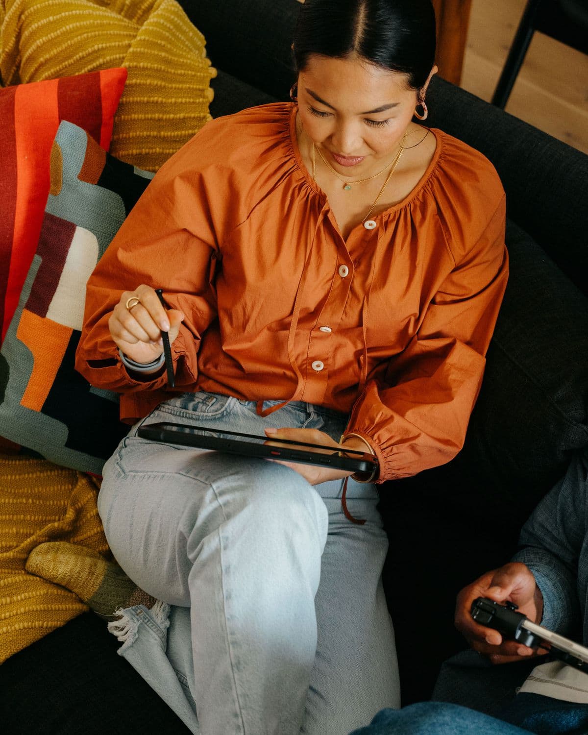 A woman on a sofa reviewing her store on a tablet